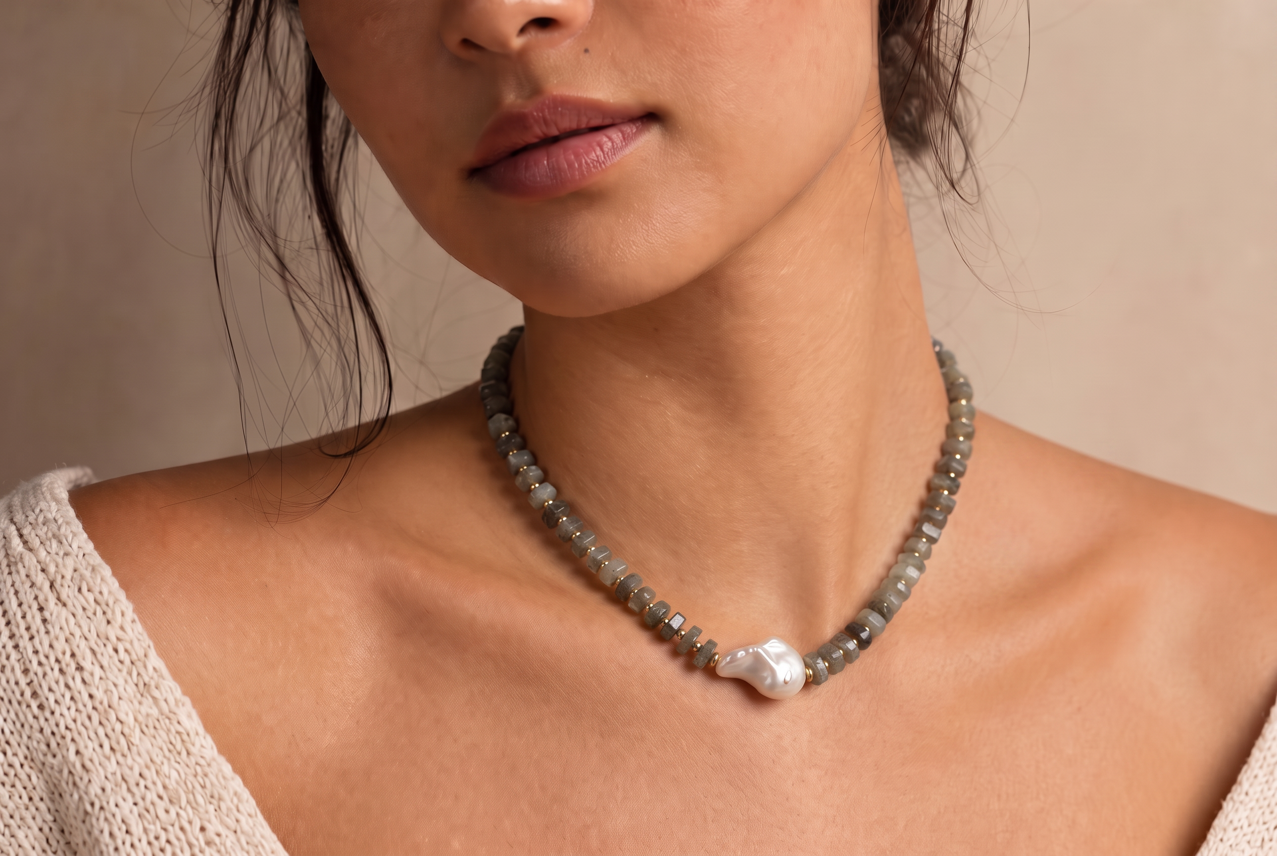 Studio close-up of a model wearing the Lo Studio labradorite bead necklace with a baroque pearl pendant
